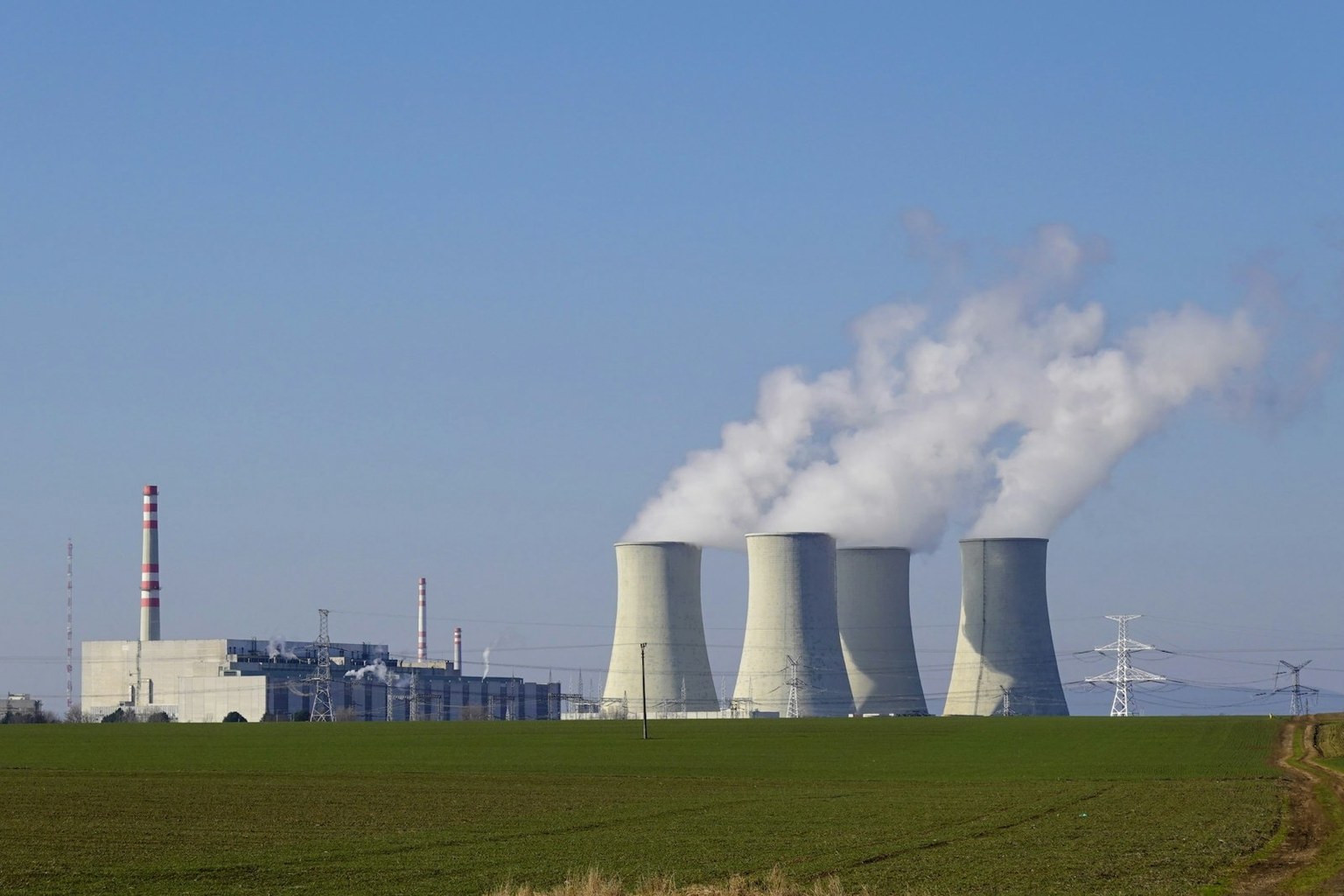 Nuclear power plant cooling towers releasing steam over open fields — generation, land and capital programme on one TerraForge hierarchy